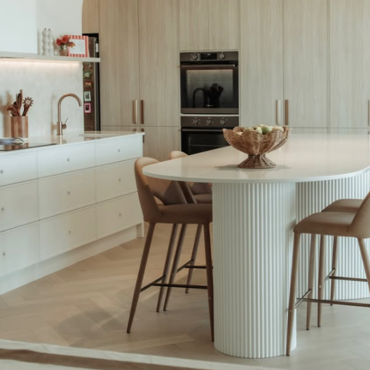 Ribbed mdf panels transform a modern curved kitchen island to create a stunning white and neutral toned designer kitchen.